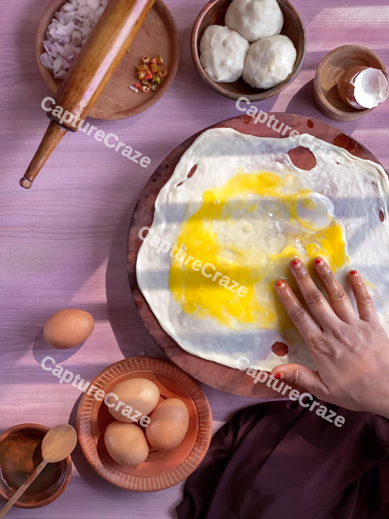 Female hands mixing an egg over dough